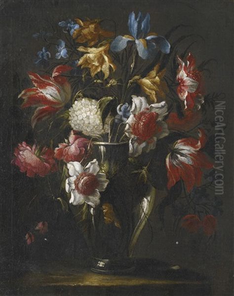 Blue Irises, Parrot Tulips, Anemones, Peonies And Other Flowers In A Glass Vase, On A Stone Ledge Oil Painting by Juan De Arellano