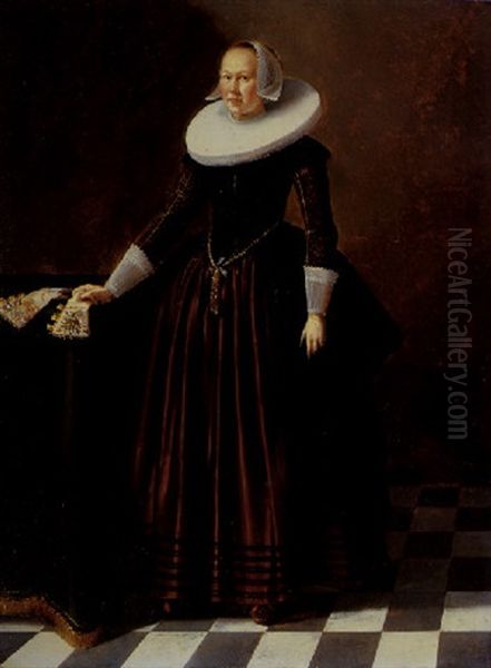 Portrait Of A Lady In An Interior Standing By A Table, Wearing A Red Satin Dress, Embroidered Bodice And White Ruff And Headdress Oil Painting by Gerard van Donck