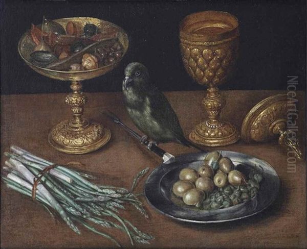 A Golden Tazza With Dates And Dried Fruits, A Golden Goblet And Cover, A Tin Plate With Olives And Capers And A Green Finch Seated On A Fork, Together With Asparagus On A Wooden Table by Georg Flegel